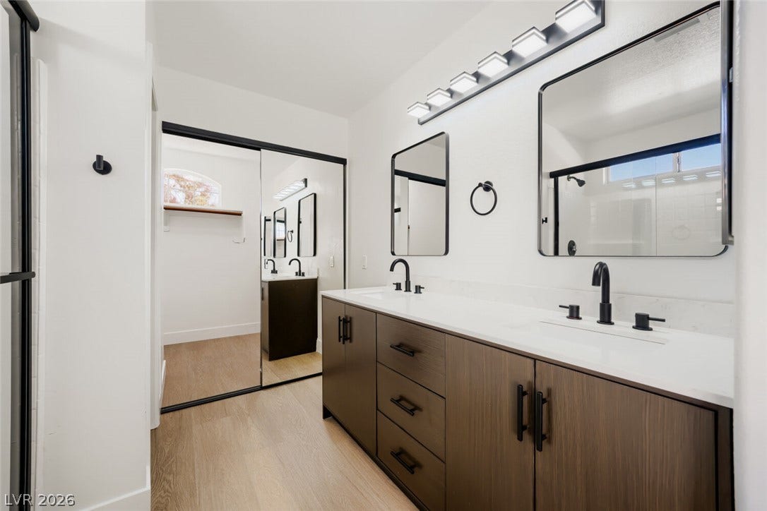 5736 Baffy Circle, Las Vegas, NV 89142 Modern stone counters and custom wood cabinetry define this beautifully updated master bathroom.