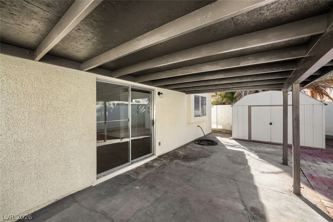 5736 Baffy Circle, Las Vegas, NV 89142 A covered concrete patio provides sheltered outdoor living space alongside the stucco home exterior.