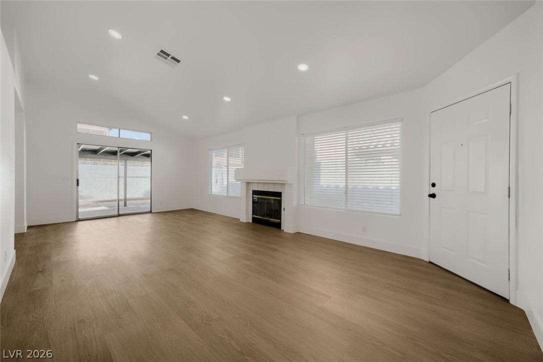 5736 Baffy Circle, Las Vegas, NV 89142 Smooth wood floors anchor this open living area featuring a central fireplace and sliding glass doors.