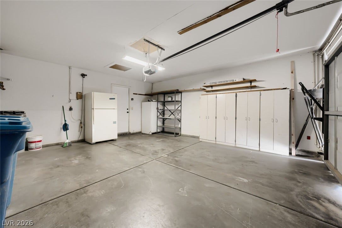 5736 Baffy Circle, Las Vegas, NV 89142 A spacious garage features durable concrete flooring and extensive built-in storage cabinets.