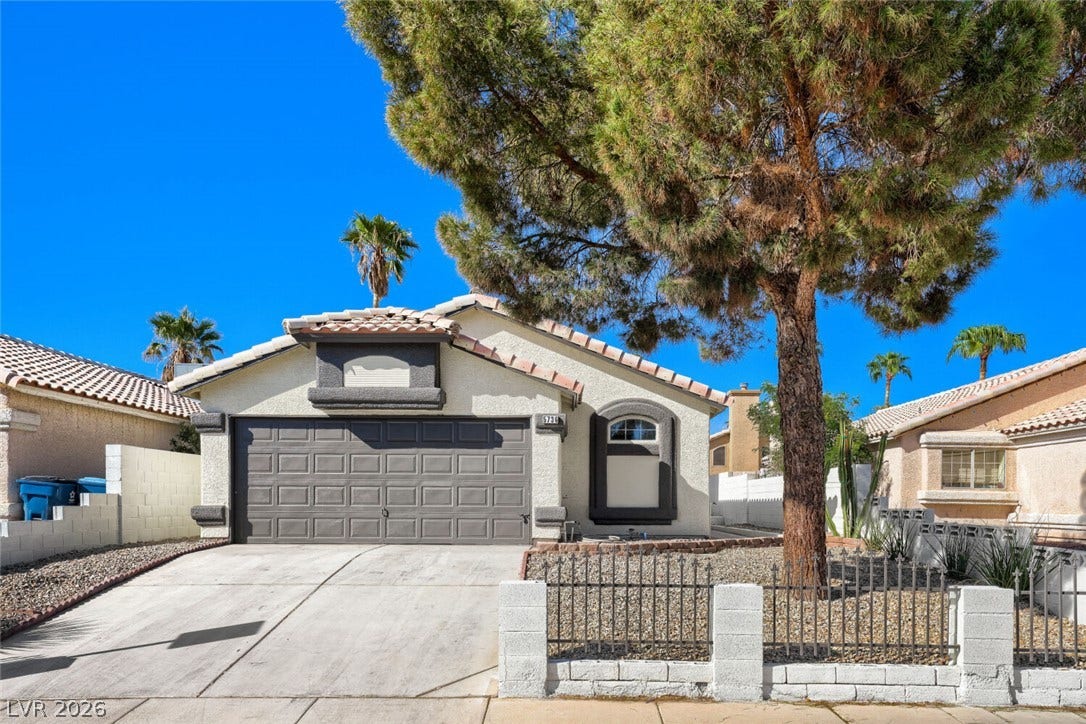 5736 Baffy Circle, Las Vegas, NV 89142 Mature trees shade the concrete driveway and neat stucco exterior of this single-story home.