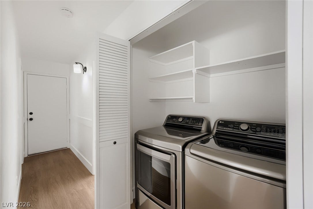 5736 Baffy Circle, Las Vegas, NV 89142 Functional laundry closet features built-in shelving above modern appliances and sleek wood-style flooring.