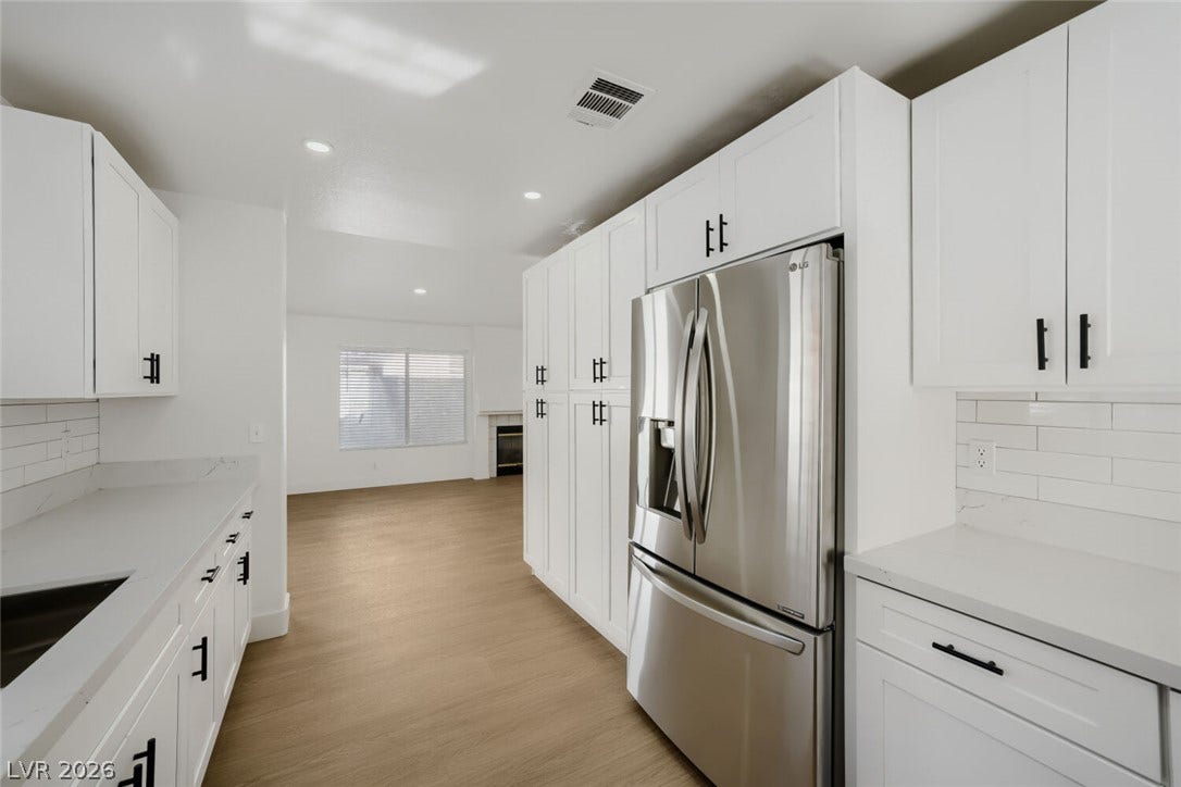 5736 Baffy Circle, Las Vegas, NV 89142 Gleaming stone countertops and modern cabinetry frame this open-concept culinary space.