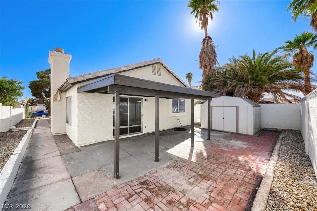 5736 Baffy Circle, Las Vegas, NV 89142 A spacious concrete and brick paved patio sits under a covered structure near a detached shed.