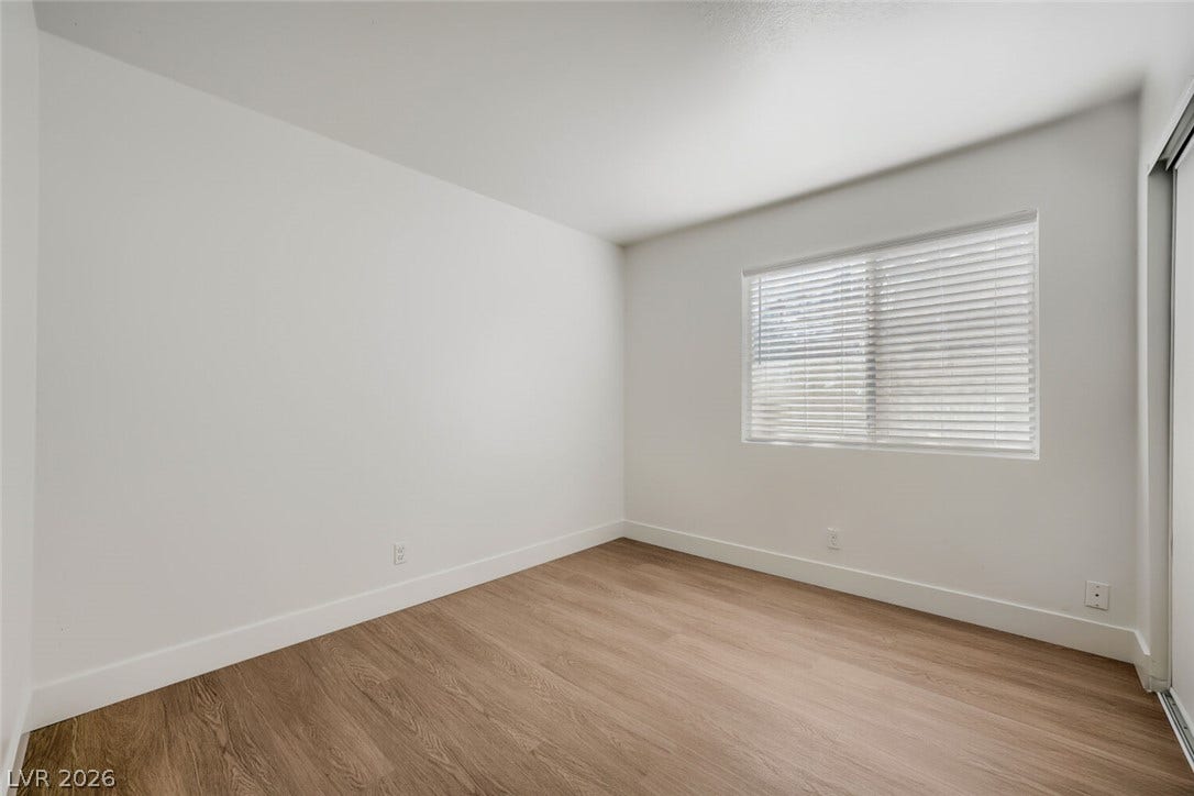 5736 Baffy Circle, Las Vegas, NV 89142 Warm wood flooring and clean white walls highlight this simple bedroom space.