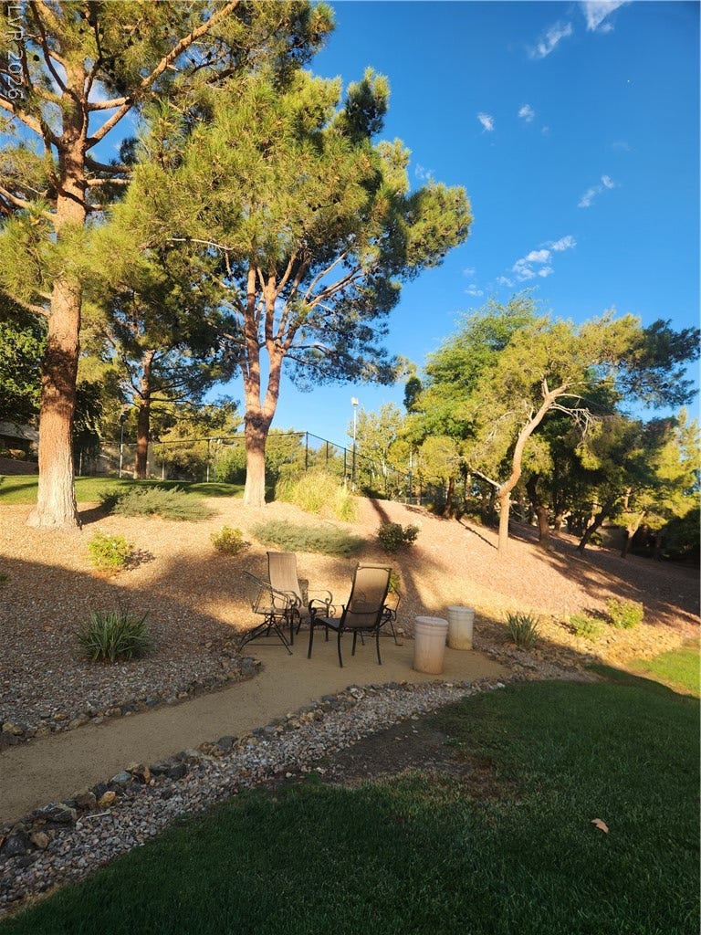 231 W Horizon Ridge Parkway, #924, Henderson, NV 89012 Mature trees line the landscaped border of a sprawling lawn under a clear sky.