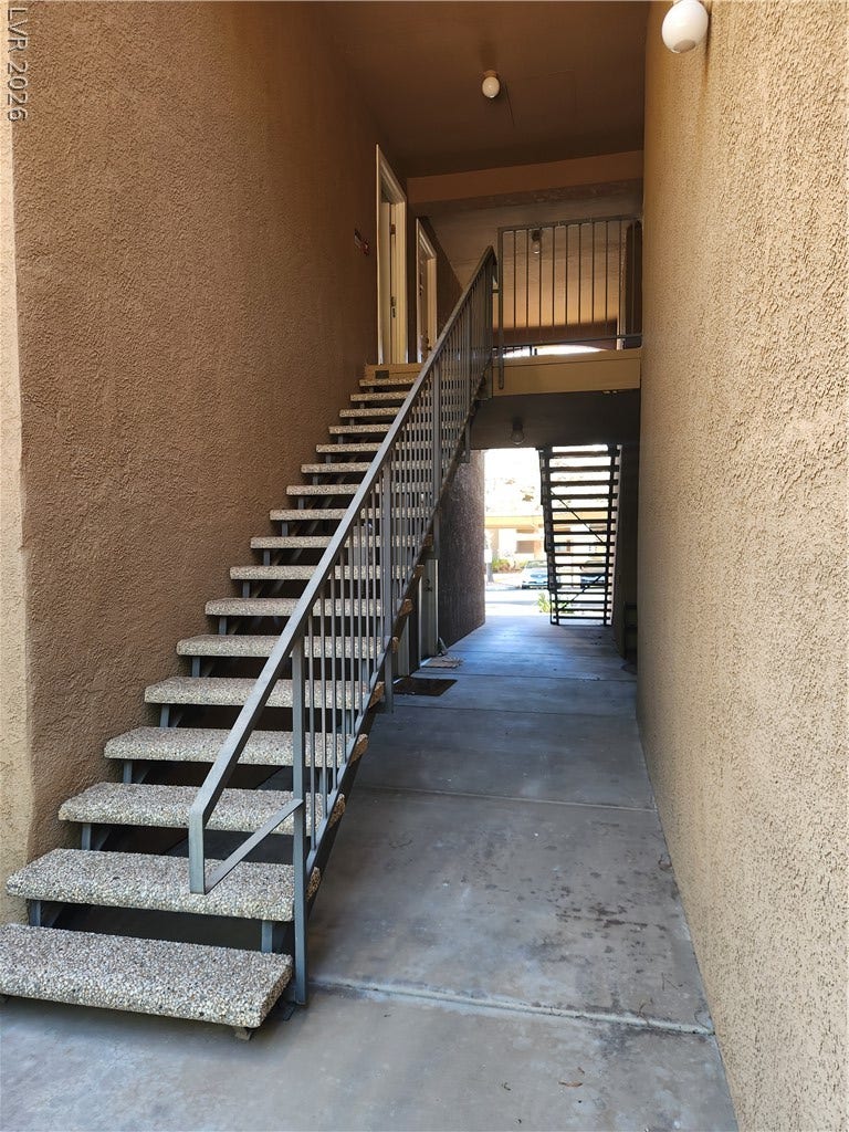 231 W Horizon Ridge Parkway, #924, Henderson, NV 89012 A stucco exterior walkway features a staircase with metal railings leading to upper levels.