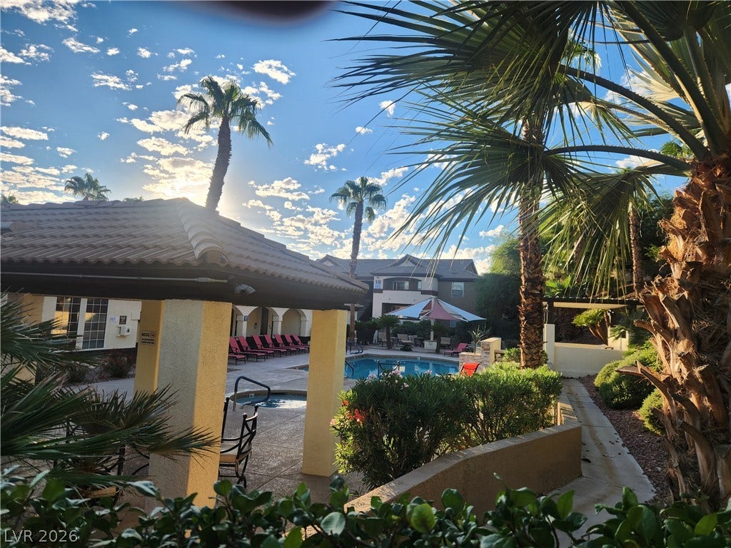 231 W Horizon Ridge Parkway, #924, Henderson, NV 89012 Lush palm trees frame a sparkling community swimming pool area under a bright sky.