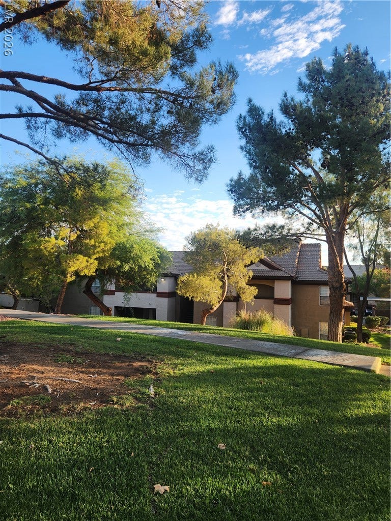 231 W Horizon Ridge Parkway, #924, Henderson, NV 89012 Mature trees shade a manicured lawn framing the stucco facade of this multi-story residence.