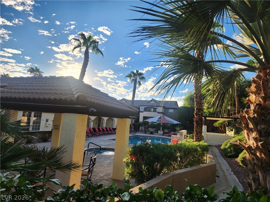 231 W Horizon Ridge Parkway, #924, Henderson, NV 89012 Lush palm trees frame a sparkling community pool area beneath a bright desert sky.