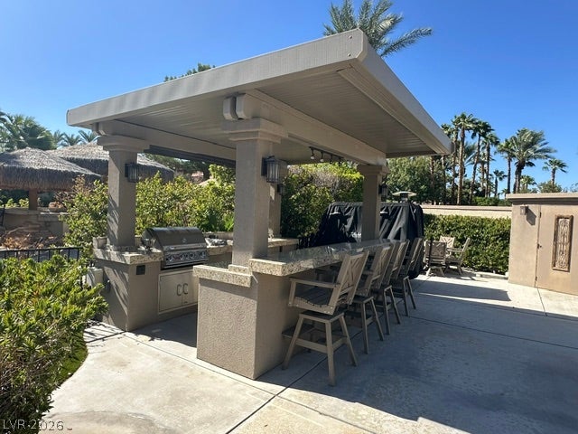 8175 Arville Street, #163, Las Vegas, NV 89139 An outdoor kitchen with built-in grilling and bar seating sits under a solid cover.