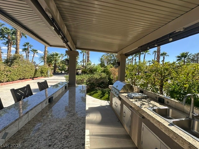 8175 Arville Street, #163, Las Vegas, NV 89139 An outdoor kitchen features granite countertops, a built-in barbecue, and a spacious breakfast bar.