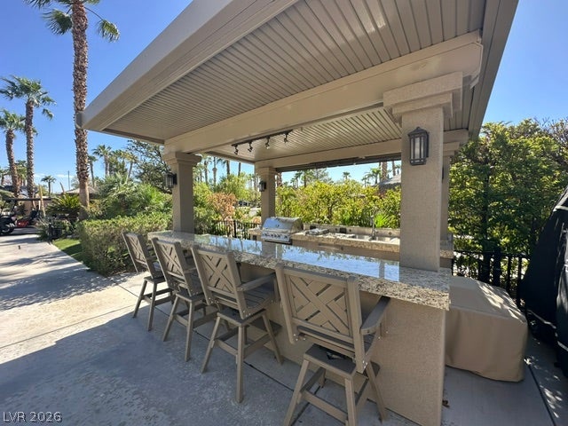 8175 Arville Street, #163, Las Vegas, NV 89139 A fully covered outdoor kitchen features a granite-topped bar and built-in cooking appliances.
