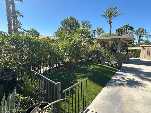 8175 Arville Street, #163, Las Vegas, NV 89139 Lush palms and manicured hedges frame a private grassy lawn next to the concrete patio.