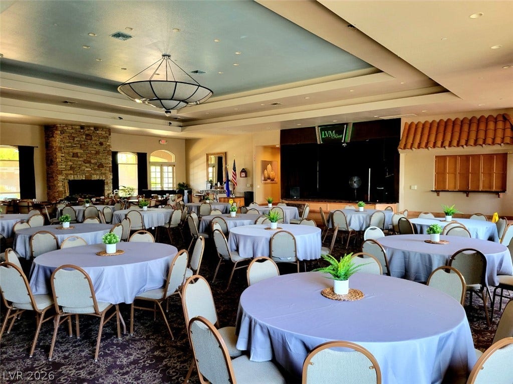8175 Arville Street, #163, Las Vegas, NV 89139 A spacious banquet hall features patterned carpeting, a stone fireplace, and tray ceilings.
