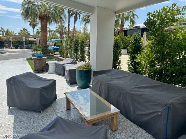8175 Arville Street, #236, Las Vegas, NV 89139 Shaded outdoor living space features aggregate flooring and views of surrounding palm trees.