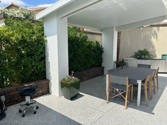 8175 Arville Street, #236, Las Vegas, NV 89139 An inviting covered patio features modern dining space flanked by structured brick planters.