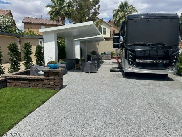 8175 Arville Street, #236, Las Vegas, NV 89139 An expansive paved driveway features custom shade structures alongside a manicured lawn.