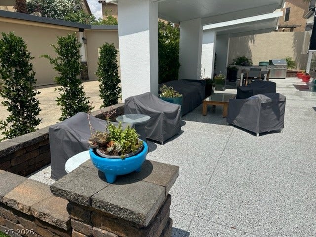 8175 Arville Street, #236, Las Vegas, NV 89139 A spacious outdoor terrace offers a covered seating area alongside low stone walls.