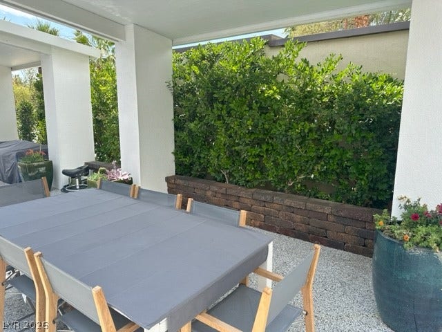 8175 Arville Street, #236, Las Vegas, NV 89139 Sheltered by a solid overhang, this gravel patio borders a raised brick planter and lush hedges.