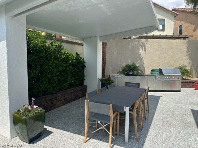 8175 Arville Street, #236, Las Vegas, NV 89139 A covered patio structure shelters a dining area adjacent to a built-in outdoor kitchen.