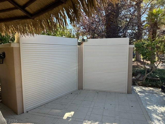 8175 Arville Street, #266, Las Vegas, NV 89139 A paved patio area features secure roll-down shutters nestled beneath a thatched roof structure.