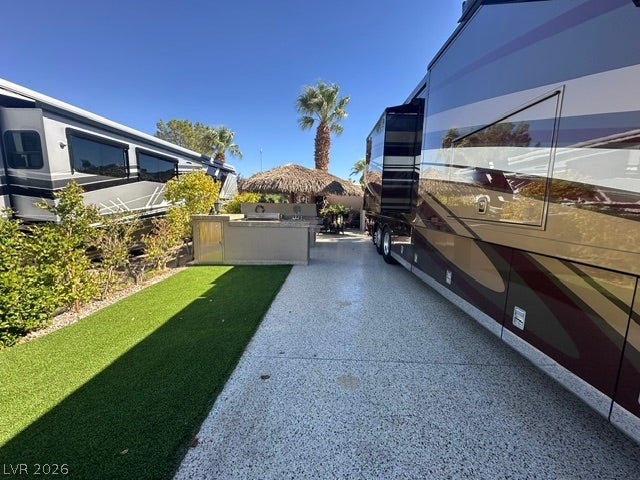 8175 Arville Street, #266, Las Vegas, NV 89139 A spacious paved pad offers dedicated motorhome parking alongside a manicured green lawn.
