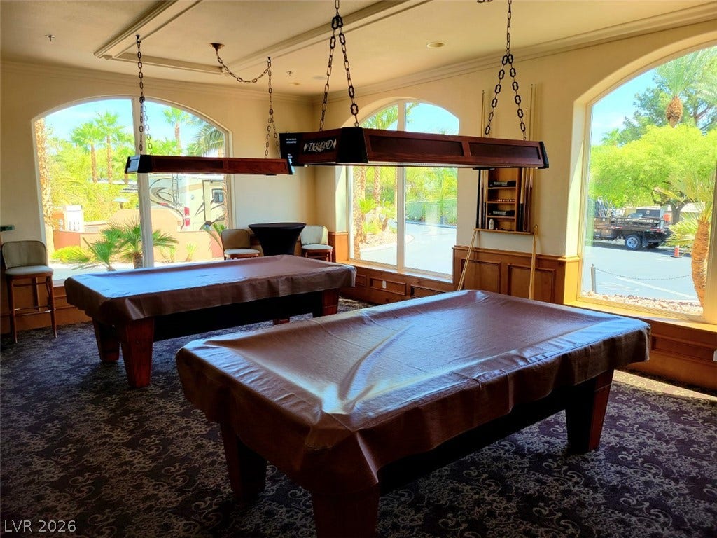 8175 Arville Street, #266, Las Vegas, NV 89139 Arched windows frame sunny palm views in this spacious recreational space featuring patterned carpeting.