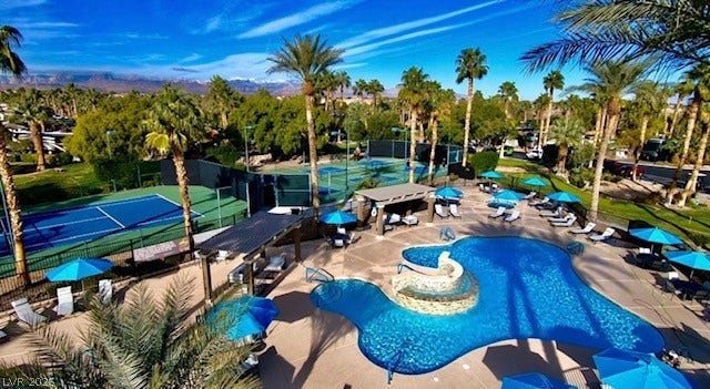 8175 Arville Street, #266, Las Vegas, NV 89139 Lush palm trees surround a resort-style swimming pool and adjacent sports courts.