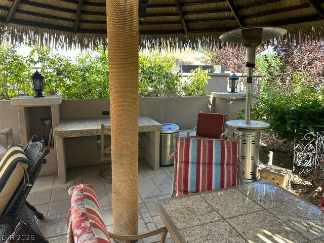 8175 Arville Street, #266, Las Vegas, NV 89139 An inviting outdoor kitchen area rests beneath a shaded palapa structure on the paved patio.