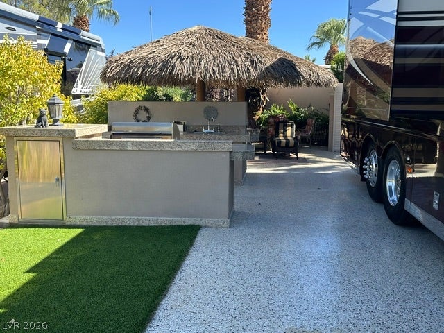 8175 Arville Street, #266, Las Vegas, NV 89139 An outdoor kitchen with granite countertops sits alongside a spacious paved lot.