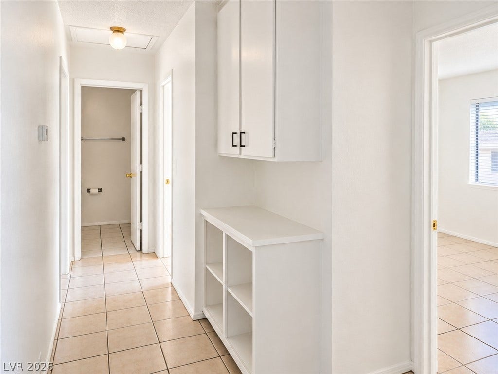 Tiled flooring and built-in cabinetry define this functional hallway space.