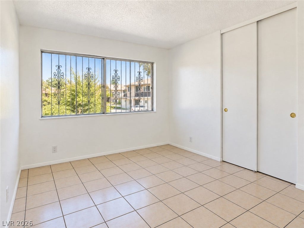 Tiled flooring and a wide window frame this versatile secondary bedroom space.
