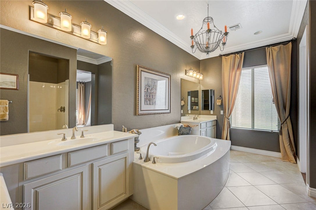 Crown molding and a corner soaking tub elevate this well-appointed bathroom.
