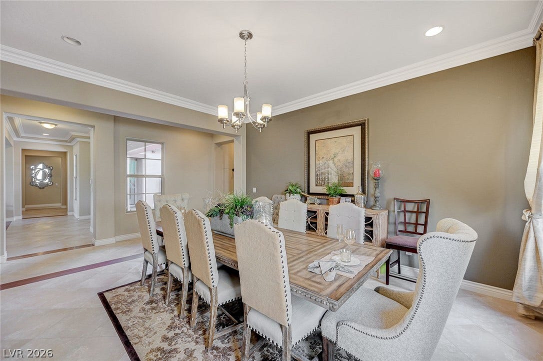 Classic crown molding and elegant tile floors define this refined formal dining area.