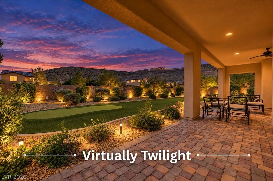 An inviting covered patio featuring brick pavers overlooks a private putting green and mountain views.