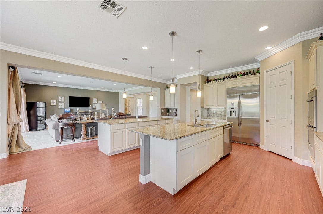 Gleaming hardwood floors and classic crown molding accent this spacious, open kitchen layout.