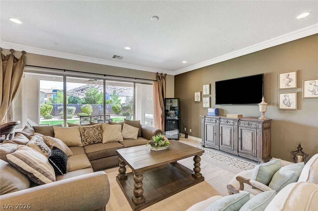 Crown molding and wide sliding glass doors define this open living area.