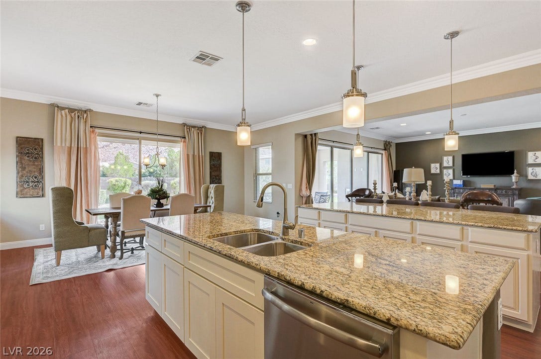 Polished granite countertops and classic wood flooring ground this open culinary space.
