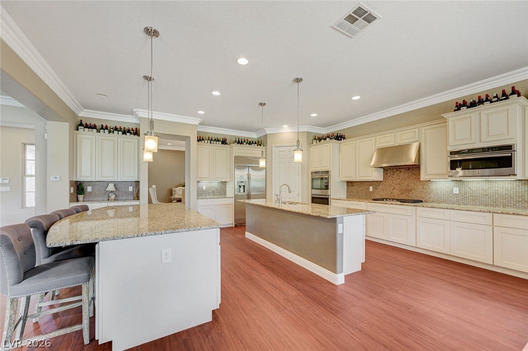 Warm wood flooring and extensive granite countertops define this spacious, open culinary space.