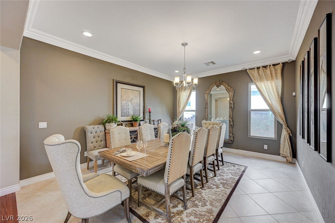 Elegant crown molding and classic tiled flooring define this formal dining space.