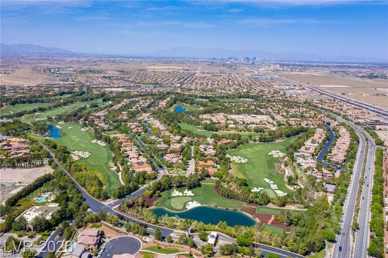 An aerial panorama captures the verdant golf course community set against a distant skyline view.
