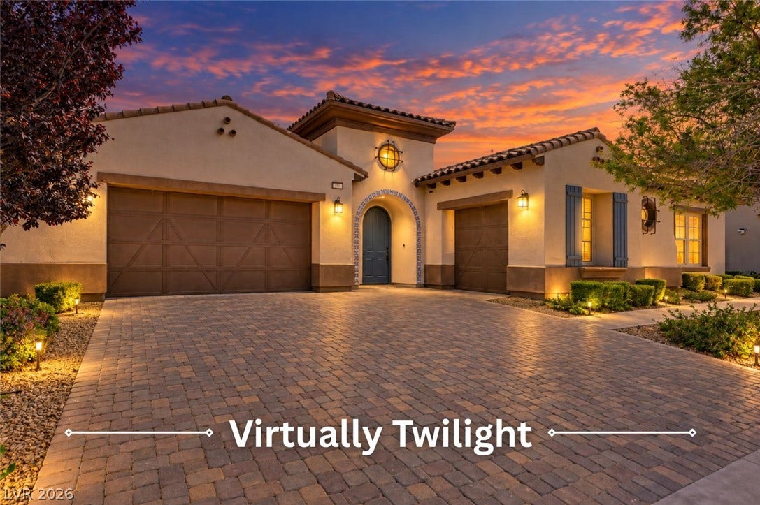 Stately architectural details and a paved drive create a welcoming entrance to this residence.