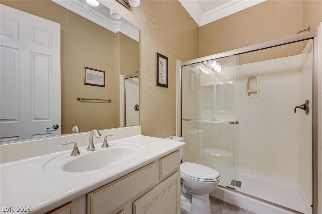 Crown molding and a modern vanity highlight this functional secondary bathroom.