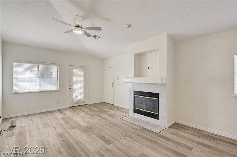 3327 Erva Street, #207, Las Vegas, NV 89117 Laminate wood flooring runs throughout a spacious room anchored by a tiled fireplace hearth.