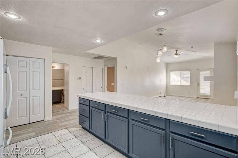 3327 Erva Street, #207, Las Vegas, NV 89117 A spacious kitchen counter transitions into the dining area with tile flooring and recessed lighting.