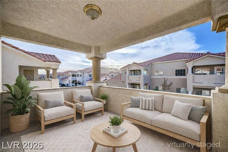 3327 Erva Street, #207, Las Vegas, NV 89117 A covered concrete balcony overlooks the surrounding neighborhood under a blue sky.