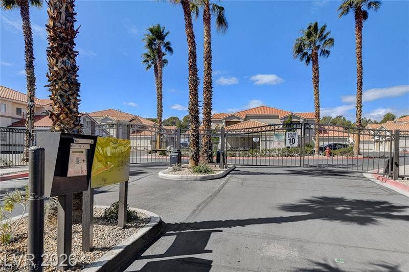 3327 Erva Street, #207, Las Vegas, NV 89117 Secure gated entry welcomes residents home beneath towering palm trees and clear blue skies.