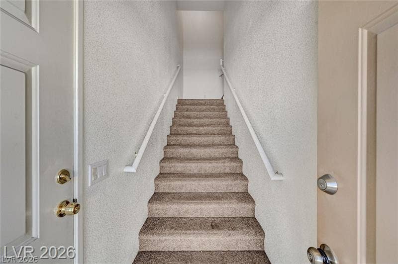 3327 Erva Street, #207, Las Vegas, NV 89117 Carpeted stairs ascend from the entry, framed by clean walls and simple handrails.