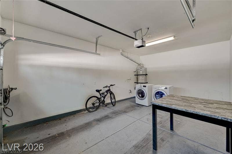 3327 Erva Street, #207, Las Vegas, NV 89117 A spacious garage features concrete flooring alongside laundry hookups and a water heater.